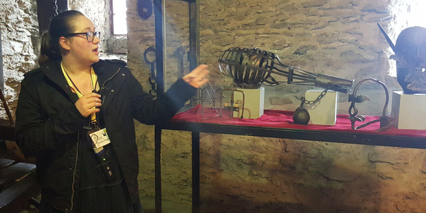 Guide Desiree Kruger shows instruments of torture. Photo / Winston Aldworth