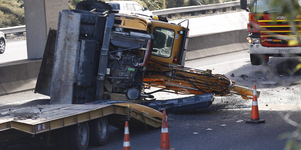 A truck carrying a tall load, a digger, collided with the Penrose Rd overpass on the southbound lanes of Auckland's Southern Motorway. Photo / Nick Reed