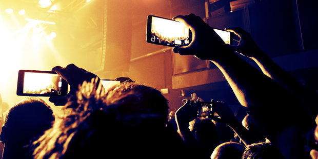 I'll never understand people who come to concerts so they can spend the entire time using their phone. Photo / iStock