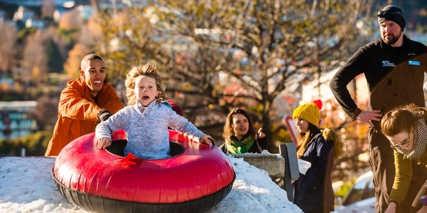 A boy enjoys tubing yesterday at Queenstown's Lakeside Park snow run, built by Coronet Peak staff. Photo / Supplied