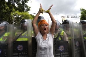 A woman protests in front of a line of Bolivarian National Police during an opposition demonstration in Caracas, Venezuela. Photo / AP