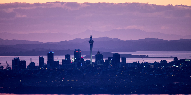 Auckland CBD at dawn, viewed from the Waitakere ranges. Photo / Michael Craig