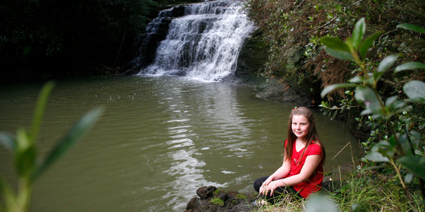 Mikayla Bourne by a waterfall in Lucas Creek, one of the waterways targeted by the Green Party. Photo / Garry Brandon