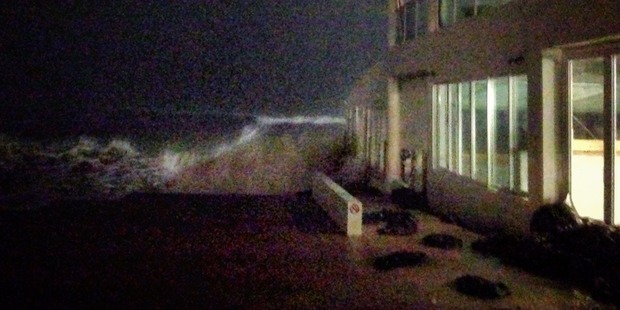 King tide swells knock out windows of Rick Shores restaurant at Burleigh Heads. Sand bags litter the ground, unable to hold out the water. Photo / Ella Wilks