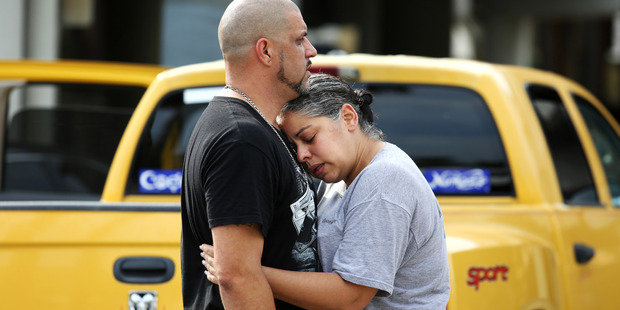 Ray Rivera, a DJ at Pulse Orlando nightclub, is consoled by a friend. Photo / Getty Images