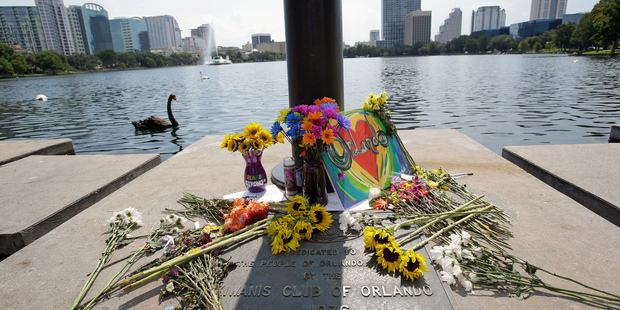 Flowers, candles and homemade signs surround a small makeshift memorial at Lake Eola park for the victims of the Pulse nightclub in Orlando. Photo / AP