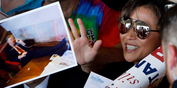 Republican Presidential candidate Donald Trump is reflected in the glasses of a supporter as he greets them and signs photographs at Pittsburgh. Photo / AP