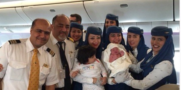 Pilots and flight staff pose with the newborn baby born on the Saudi Arabian Airlines flight. Photo / Twitter, @SultanALFuraih1