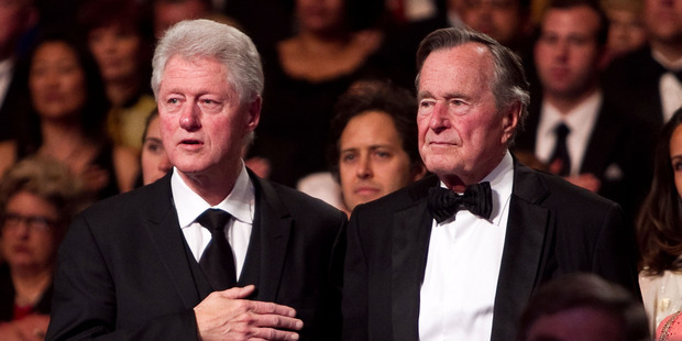 Former President Bill Clinton (L) and former President George H.W. Bush stand for the National Anthem. Photo / Getty