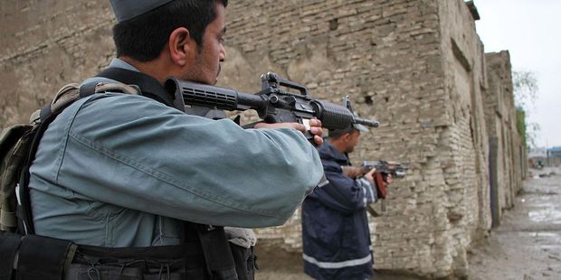 Afghan policemen keep guard at the site of the Taliban attack in front of Afghan intelligence office. Photo / Getty Images