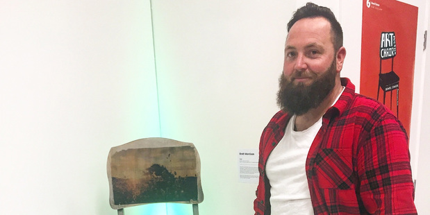 Brett Morrison with the chair that he made, which sold for $550.