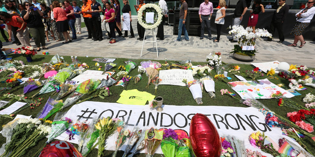 Visitors gather at a memorial for the victims of a shooting at the Pulse nightclub. Photo / AP