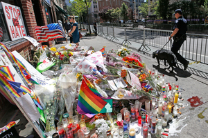 A counterterrorism officer walks his bomb-sniffing dog past a makeshift memorial for victims of the Orlando nightclub shooting in front of the Stonewall Inn. Photo / AP/Kathy Willens