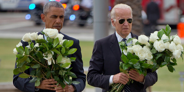 President Barack Obama with Vice President Joe Biden carry 49 white roses, one in honour of each of dead, as they visit a memorial to the victims of the Pulse nightclub shootings. Photo / AP