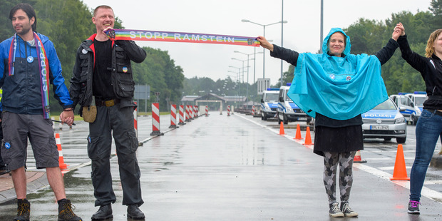 Peace activists form a human chain on the street leading towards the US air base during the 'Stopp-Ramstein' campaign in Ramstein, Germany. Photo / AP