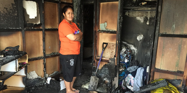 Cathlyn Pala stands in the burnt out wreckage of her home in Mangere. She rescued her three nieces when fire broke out in the morning of 12 May 2016. Photo / Susan Strongman
