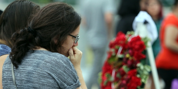 Visitors mourn the victims of the shooting in Orlando. Photo / AP