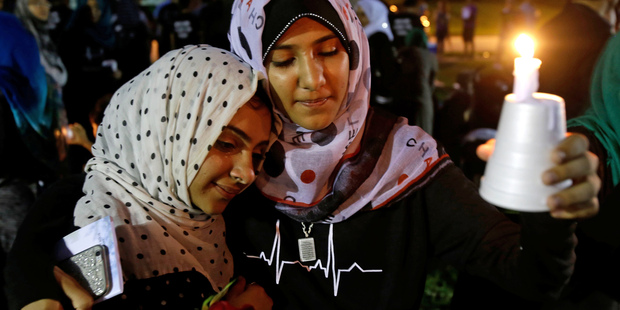 Supporters of the victims of the mass shooting at the Pulse nightclub attend a vigil at Lake Eola Park, Orlando. Photo / AP