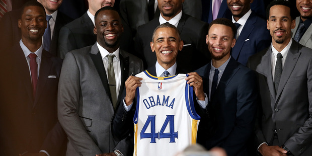U.S. President Barack Obama holds a Golden State Warriors basketball jersey presented to him during an event with the team. Photo / Getty