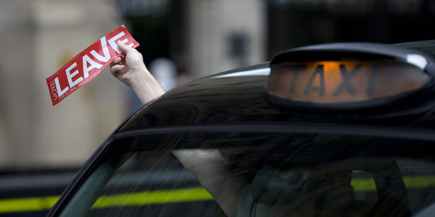 A Black Cab driver holds a "vote leave" sticker out his window. Photo / Getty