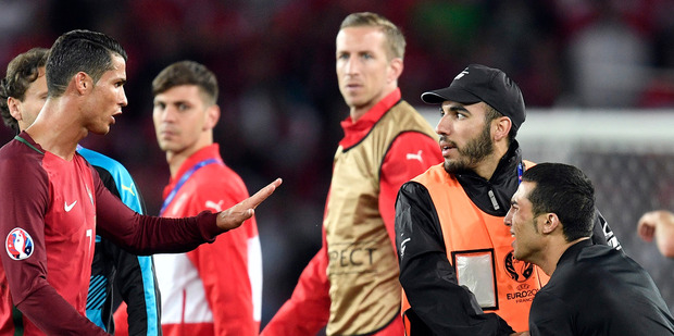 Cristiano Ronaldo in one of his better moods gestures to a steward to allow a man who invaded the pitch to take a selfie with him at the end of the match between Portugal and Austria. Photo / AP