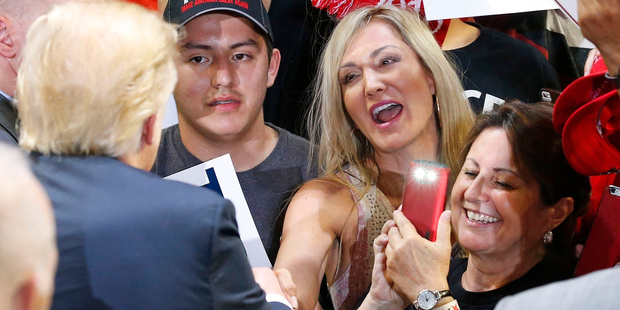 Republican presidential candidate Donald Trump signs autographs for supporters after speaking at a rally. Photo / AP
