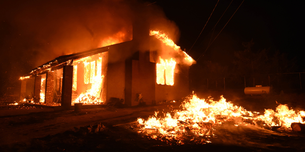 A home is fully engulfed in a fire caused by a fast burning wildfire in the section of South Lake near Lake Isabella, California. Photo / AP