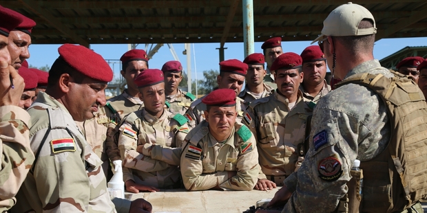 A New Zealand soldier helps Iraqi troops with weapons training at Taji Military Base. Photo / US Army