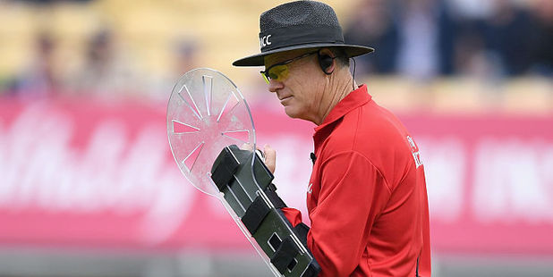 Umpire Bruce Oxenford holds his custom-built protective shield. Photo / Getty Images