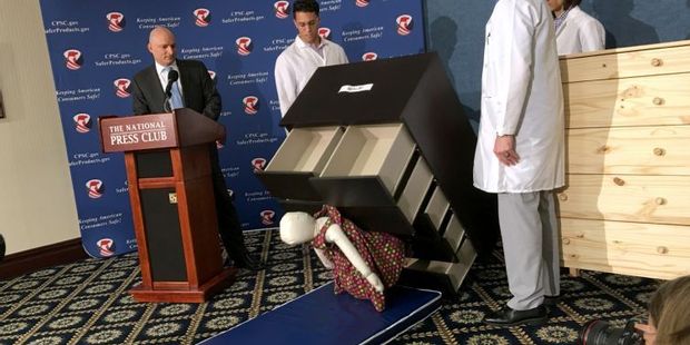 Consumer Product Safety Commission employees watch as a 13 kilo dummy falls over and under IKEA Malm model chest of drawers. Photo / AFP