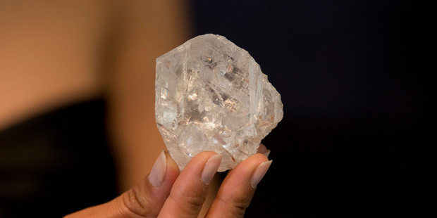 A model poses for photographs holding up the largest gem-quality rough cut diamond discovered in over 100 years. Photo / AP