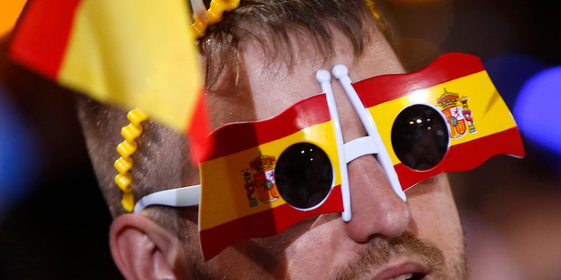 A follower of Spain's acting Primer Minister and candidate of Popular Party Mariano Rajoy, celebrates the election results in Madrid. Photo / AP