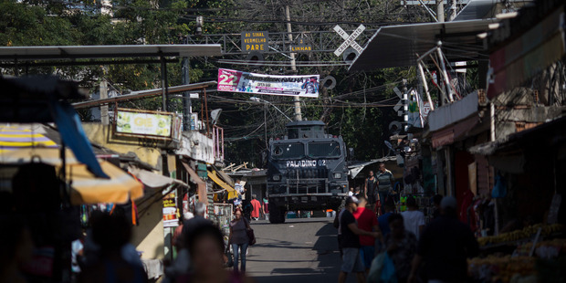 An armoured police vehicle patrols a busy street during an operation against drug traffickers at the Jacarezinho slum in Rio de Janeiro, Brazil. Photo / AP