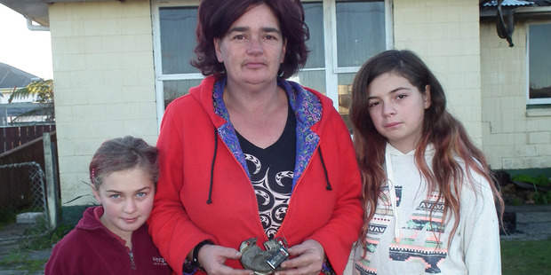 (L-R) Chloe, Katrina Smith and Elli with the remains of one of the smoke alarms that saved their lives. Photo / Westport News