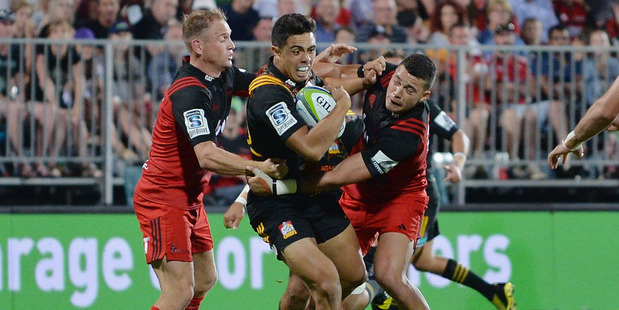 Anton Lienert-Brown of the Chiefs is tackled by Andy Ellis (L) and David Havili of the Crusaders during the round one Super Rugby match. Photo / Getty Images