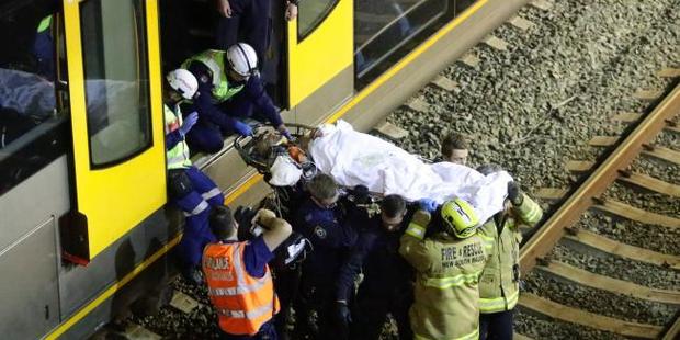 Rescuers work to free the man, who fell under an oncoming train. Photo / Bill Hearne