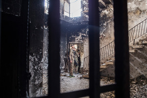 A Swat soldier looks at the building where they found an Isis prison in Fallujah. The downstairs rooms were used as group cells, and the upstairs for solitary confinement. Photo / The Washington Post