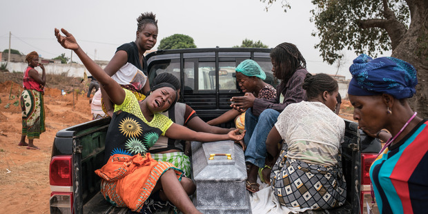 Women grieve over the casket of a young boy who had died two days prior in Luanda, Angola. Photo / Washington Post