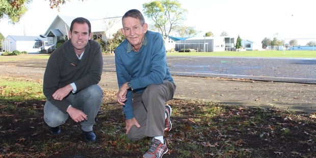 Puketaha School principal Geoff Booth (left) with centenary organiser Bryan Mayall at the plaque where one of the time capsules was believed to be buried.