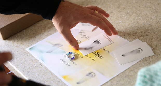 Photographer Shane Epping arranges footprint cards during a photo shoot for Kyson, who died at 34 weeks on Feb. 17, at the University of Missouri Women's and Children's Hospital in Columbia Photo / The Washington Post by Timothy Tai