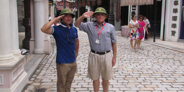 Tourist guide Jackie Li and Rod Pascoe don Red Army helmets in Movie Town. Photo / Barbara Boyce