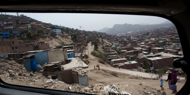 A van carries tourists through the Villa Maria del Triunfo district on the outskirts of Lima, Peru. Photo / AP