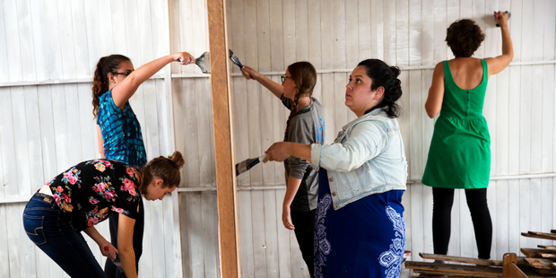 Tourists volunteer to paint a new community nursery and primary school as part of their tour of a shantytown. Photo / AP