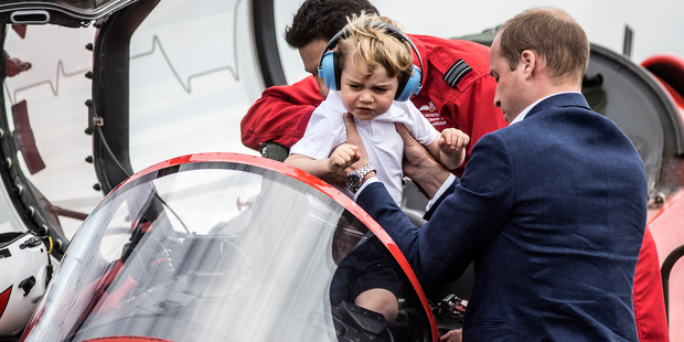 Prince George is lifted out of the cockpit of a red arrows plane by his father Prince William. Photo / AP