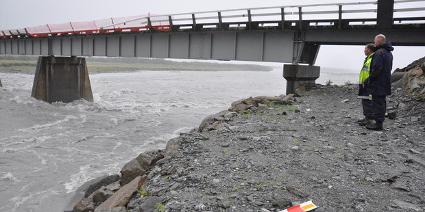 West Coast police search and rescue co-ordinator sergeant Sean Judd and police dive team supervisor Geoff Bray, right, look over the swollen Wanganui River. Photo / File