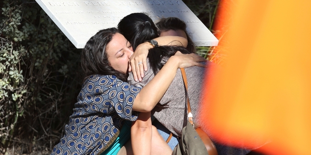 Parents of victims embrace each other near the scene of a truck attack in Nice. Photo / AP