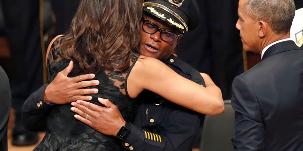 First lady Michelle Obama, left, hugs Dallas Police Chief David Brown, as President Barack Obama, right, watches during a memorial service in Dallas. Photo / AP