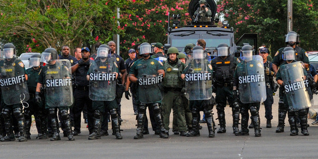 Police officers watch protesters gathering against another group of protesters in Baton Rouge, Louisiana. Photo / AP