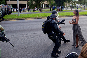 A protester is grabbed by police officers in riot gear after she refused to leave the motor way in front of the the Baton Rouge Police Department Headquarters. Photo / AP