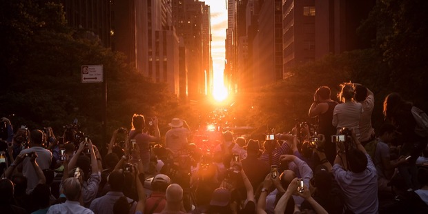 People take photographs as they view the 'Manhattanhenge' sunset. Photo / Michael Appleton, Mayoral Photography Office NYC